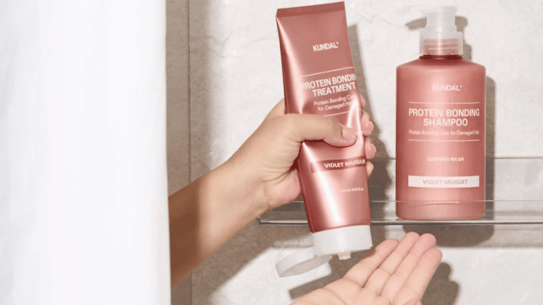Kundal Protein Bonding Shampoo och Treatment i färgen Violet Muguet på duschylla. Proteinberikad hårvård för skadat hår som stärker och återfuktar på djupet.