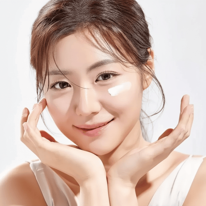 Mujer aplica Round Lab 1025 Dokdo Eye Cream debajo de los ojos para hidratación, luminosidad y un tono de piel más uniforme