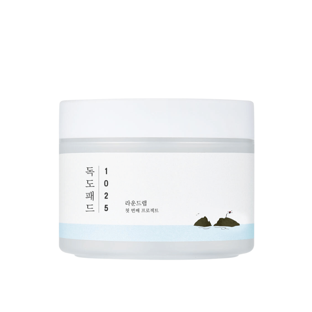 Un frasco blanco cerrado de 1025 Dokdo Pads con un diseño simple y motivo marino en la etiqueta, sobre un fondo blanco.