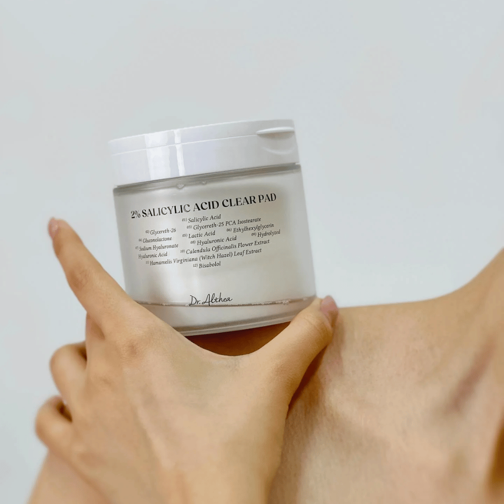 Dr. Althea 2% Salicylic Acid Clear Pad sostenido en la mano. Pads de tónico con 2% de ácido salicílico que exfolian suavemente, calman la piel y mejoran la estructura de la piel.