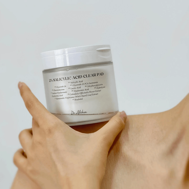 Dr. Althea 2% Salicylic Acid Clear Pad sostenido en la mano. Pads de tónico con 2% de ácido salicílico que exfolian suavemente, calman la piel y mejoran la estructura de la piel.