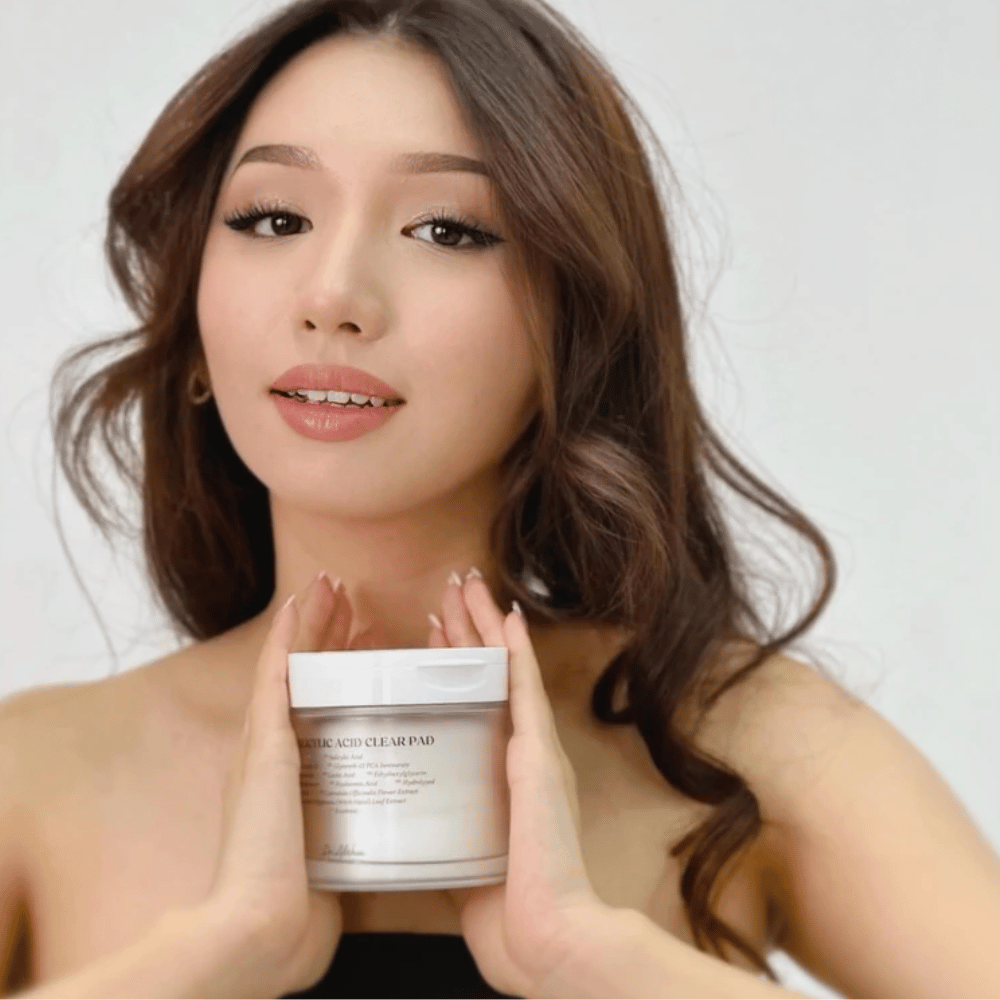Modelo sostiene Dr. Althea 2% Salicylic Acid Clear Pad frente al rostro. Pads de tónico exfoliantes con ácido salicílico que limpian los poros, equilibran el sebo y proporcionan una piel más clara.