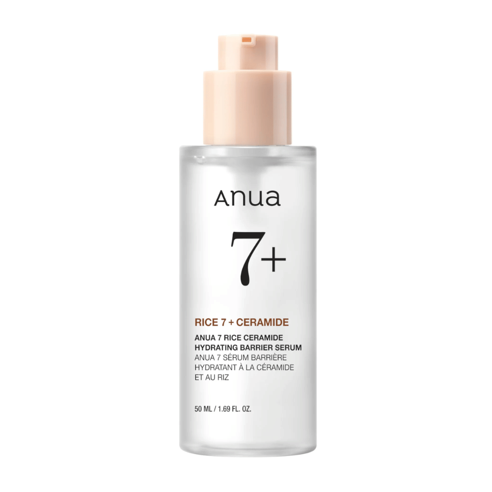 Una botella de "Anua 7+ Rice Ceramide Hydrating Barrier Serum" con un diseño claro y minimalista. El empaque es transparente con una bomba de color rosa claro, y contiene 50 ml de suero enriquecido con arroz y ceramidas para hidratar y fortalecer la barrera de la piel.
