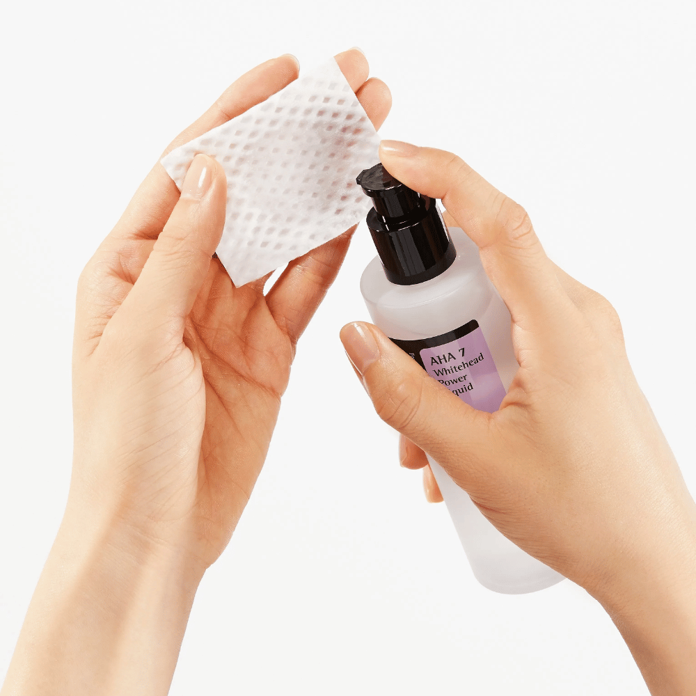 Aplicación de COSRX AHA 7 Whitehead Power Liquid en almohadilla de algodón, tónico exfoliante con AHA para eliminar células muertas de la piel y mejorar la estructura de la piel.