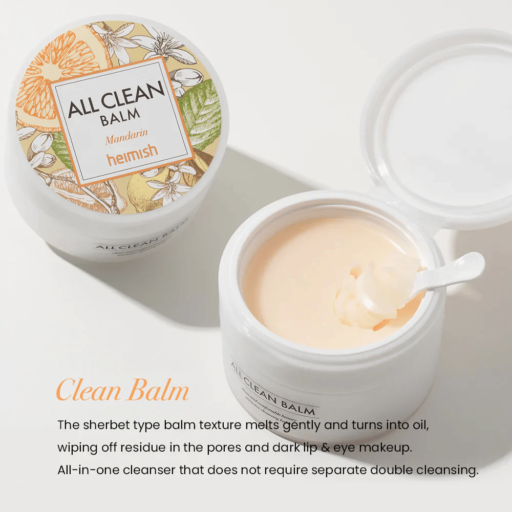 Frasco abierto de Heimish All Clean Balm Mandarin con una cuchara revolviendo el bálsamo de limpieza cremoso, con una etiqueta colorida y el texto 'Clean Balm' en primer plano.