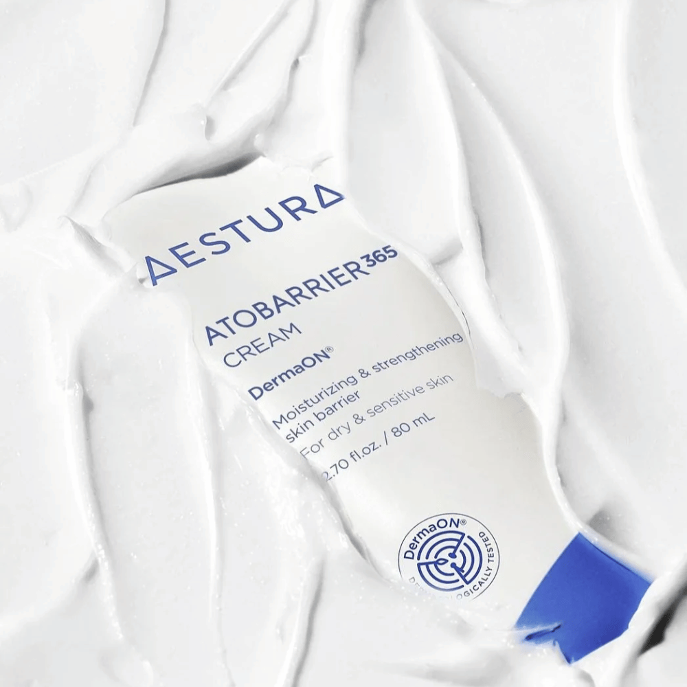 Aestura Atobarrier 365 Cream es perfecto para piel seca y sensible. Con tecnología DermaON™, esta crema hidrata y fortalece la barrera cutánea. El producto se muestra aquí en un tubo de 80 ml, parcialmente cubierto por su propia consistencia cremosa, lo que resalta sus ricas propiedades hidratantes.