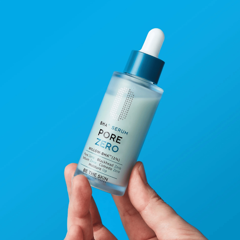 Be The Skin BHA+ Pore Zero Serum sostenido en la mano sobre fondo azul
