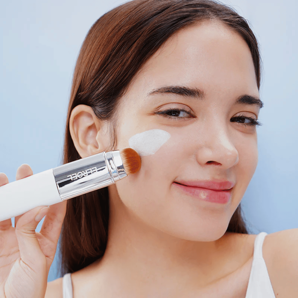 Modelo aplica ELROEL Blanc Cover Cream Stick concealer en la mejilla con pincel integrado para cobertura natural y uniforme.