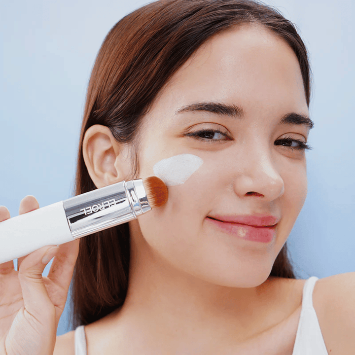 Modelo aplica ELROEL Blanc Cover Cream Stick concealer en la mejilla con pincel integrado para cobertura natural y uniforme.