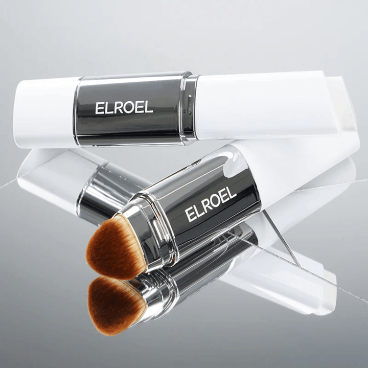 ELROEL Blanc Cover Cream Stick con pincel integrado colocado sobre una superficie de espejo para mostrar cerdas suaves y aplicación uniforme.