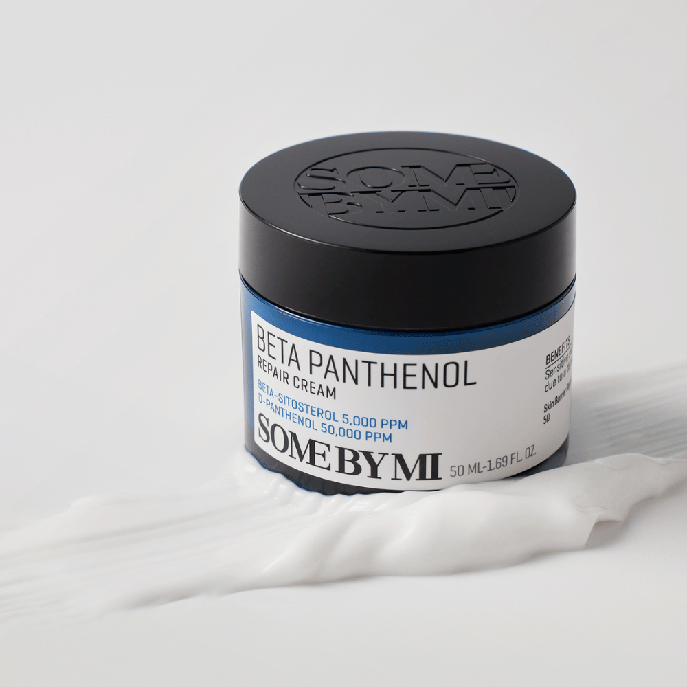 SOME BY MI Beta Panthenol Repair Cream en tarro azul colocada sobre textura de crema – crema calmante e hidratante para la piel.