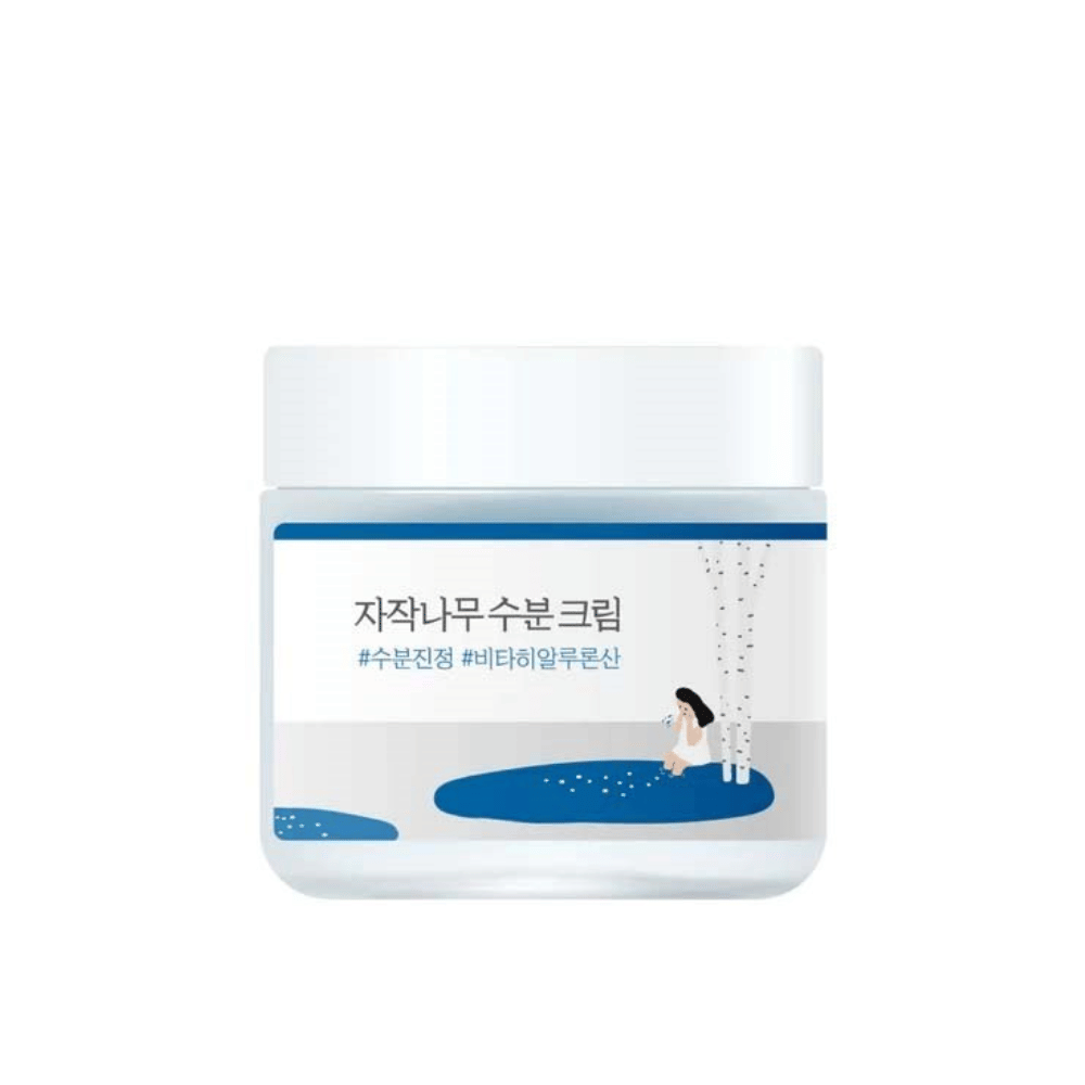 Round Lab Birch Juice Moisturizing Cream en frasco transparente con tapa blanca y etiqueta azul con ilustración de abedul y niña, aislado sobre fondo blanco.