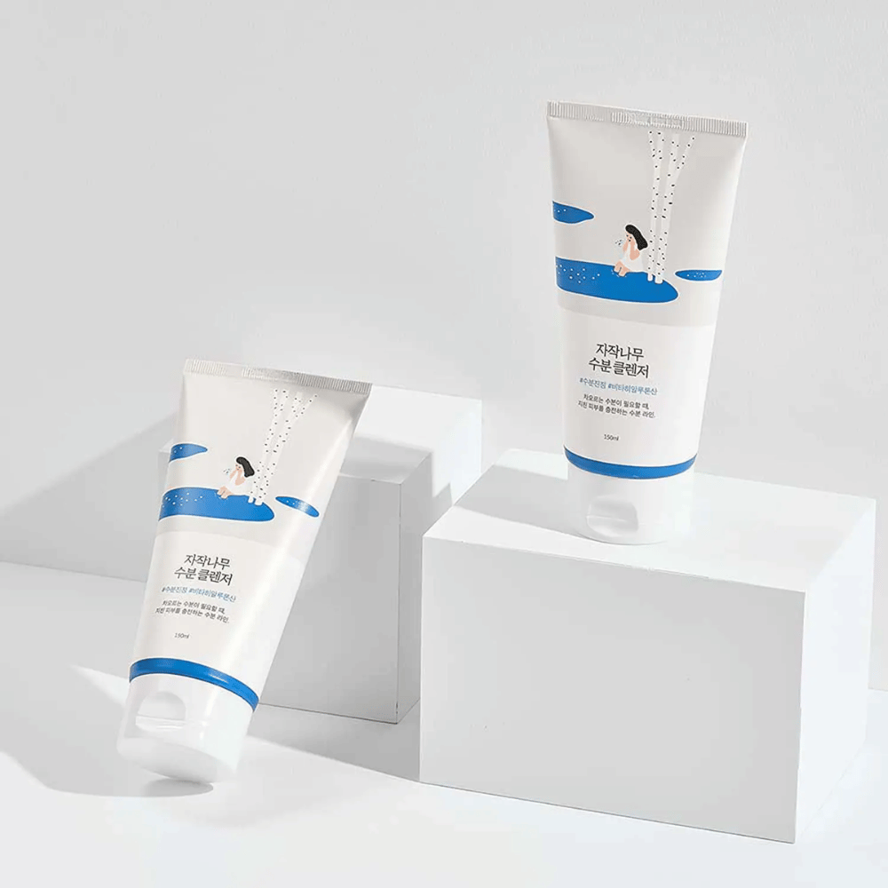 ROUND LAB Birch Juice Moisturizing Cleanser en dos tubos sobre fondo blanco, limpiador facial suave e hidratante con savia de abedul que limpia suavemente y es adecuado para todo tipo de piel, incluso piel sensible.