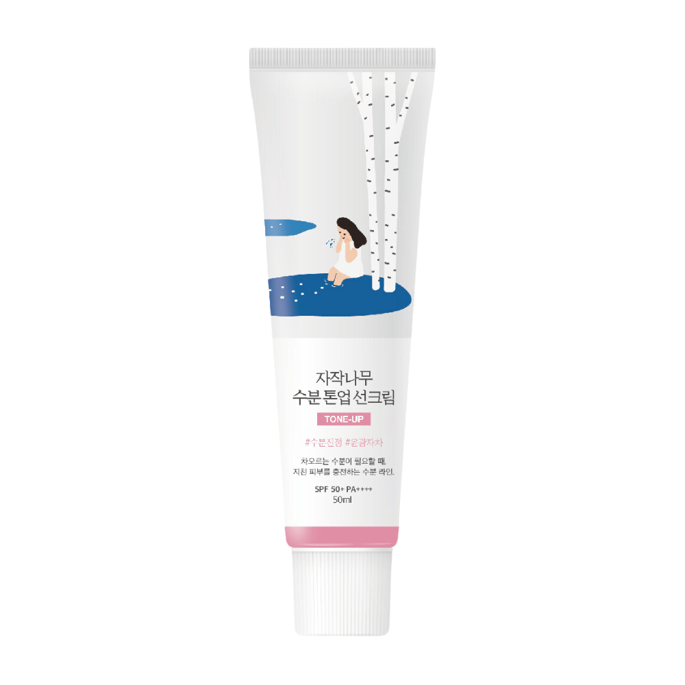 Un tubo blanco con Birch Juice Moisturizing Tone Up Sunscreen. El tubo tiene una ilustración de una mujer sentada junto a un abedul al lado de un charco de agua. El texto en el tubo está en coreano e indica que el producto tiene SPF 50+ PA++++ y contiene 50 ml.