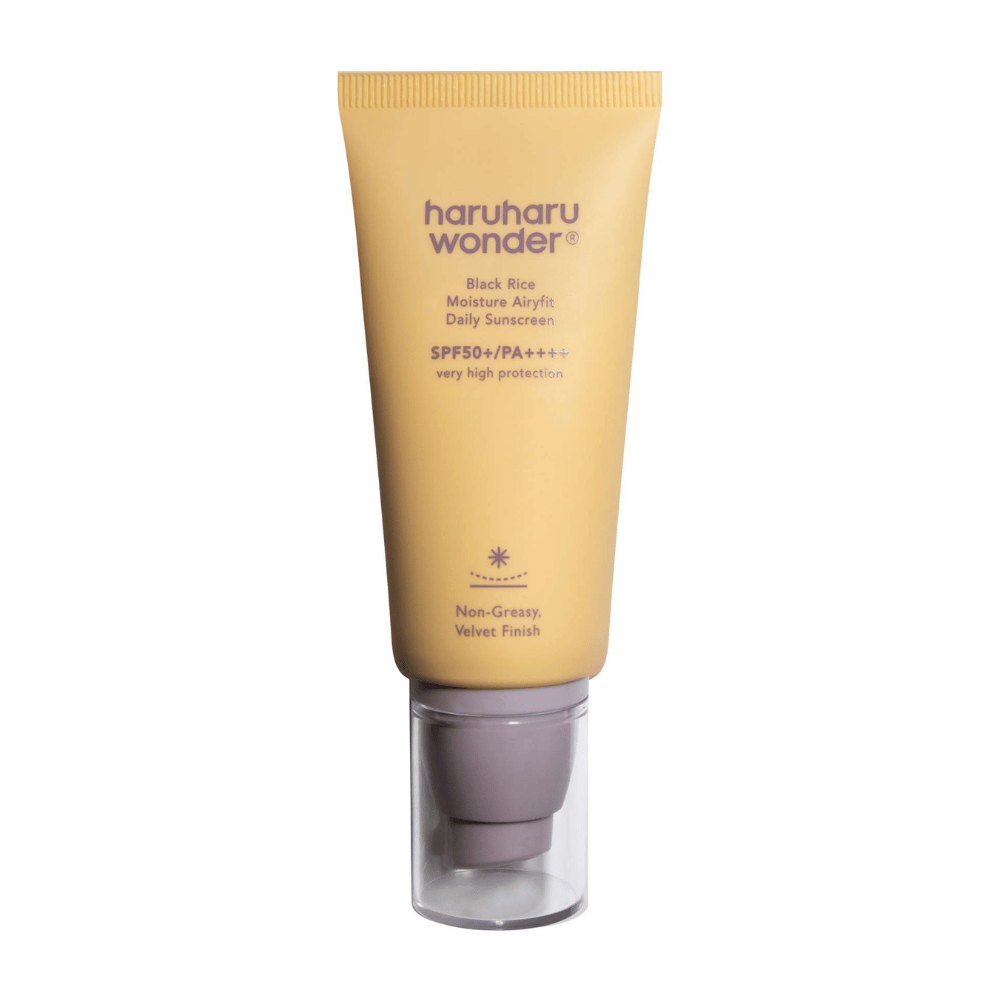 Un tubo amarillo con Haruharu Wonder Black Rice Moisture Airyfit Daily Sunscreen SPF 50+ PA++++. El tubo tiene una tapa transparente y texto que describe el alto nivel de protección del protector solar y su acabado no graso y aterciopelado.