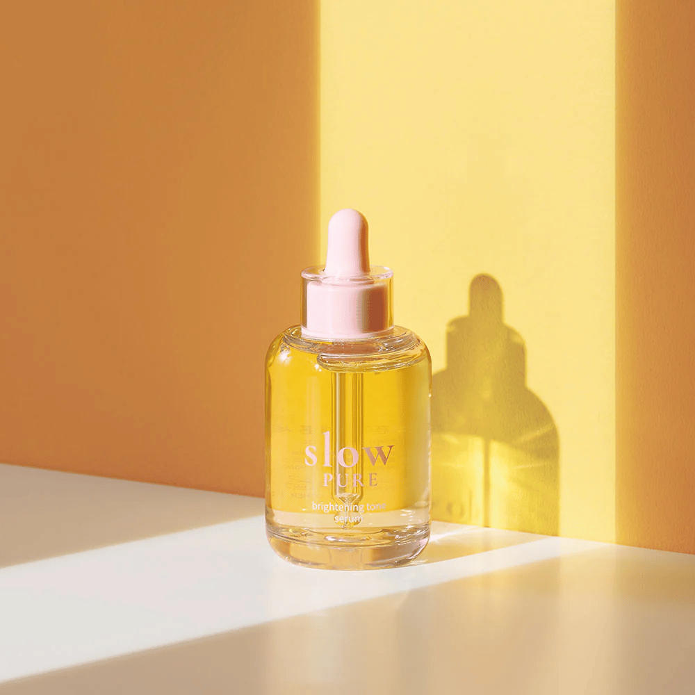 Slow Pure Brightening Tone Serum en luz amarilla soleada, simboliza brillo y energía para la piel.