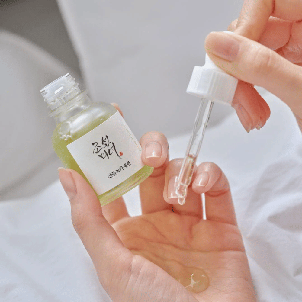 Mano goteando Beauty of Joseon Calming Serum Té Verde + Pantenol en la piel – suero coreano calmante para piel sensible.