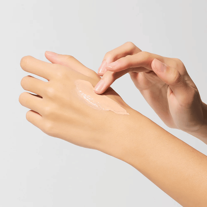 Aplicación de Dr.Melaxin Cemenrete Eye Cream en la mano, contorno de ojos cremosa con calcio y elastina que se absorbe rápidamente y proporciona hidratación intensa.