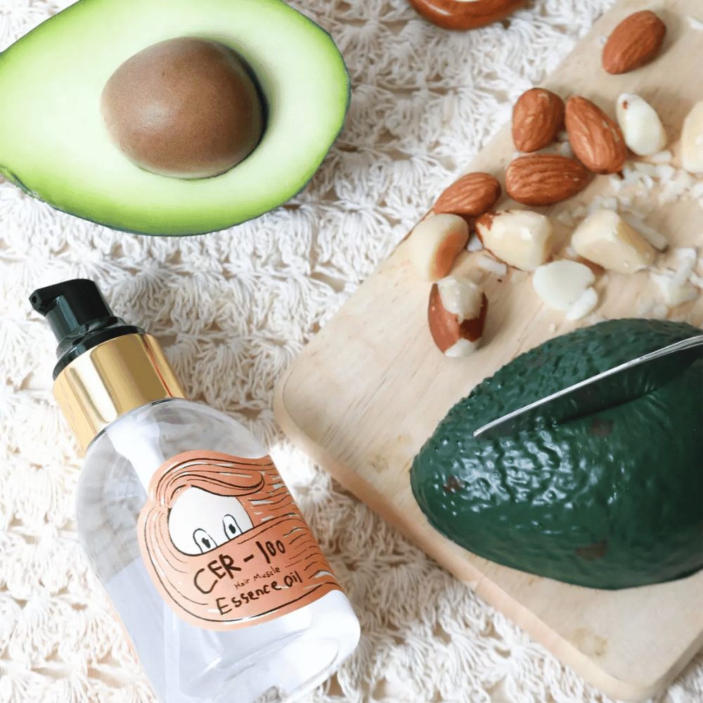 Elizavecca CER-100 Hair Muscle Essence Oil ingredientes – primer plano con aguacate y aceites vegetales que muestra un aceite para el cabello nutritivo que ayuda a suavizar y cuidar el cabello.