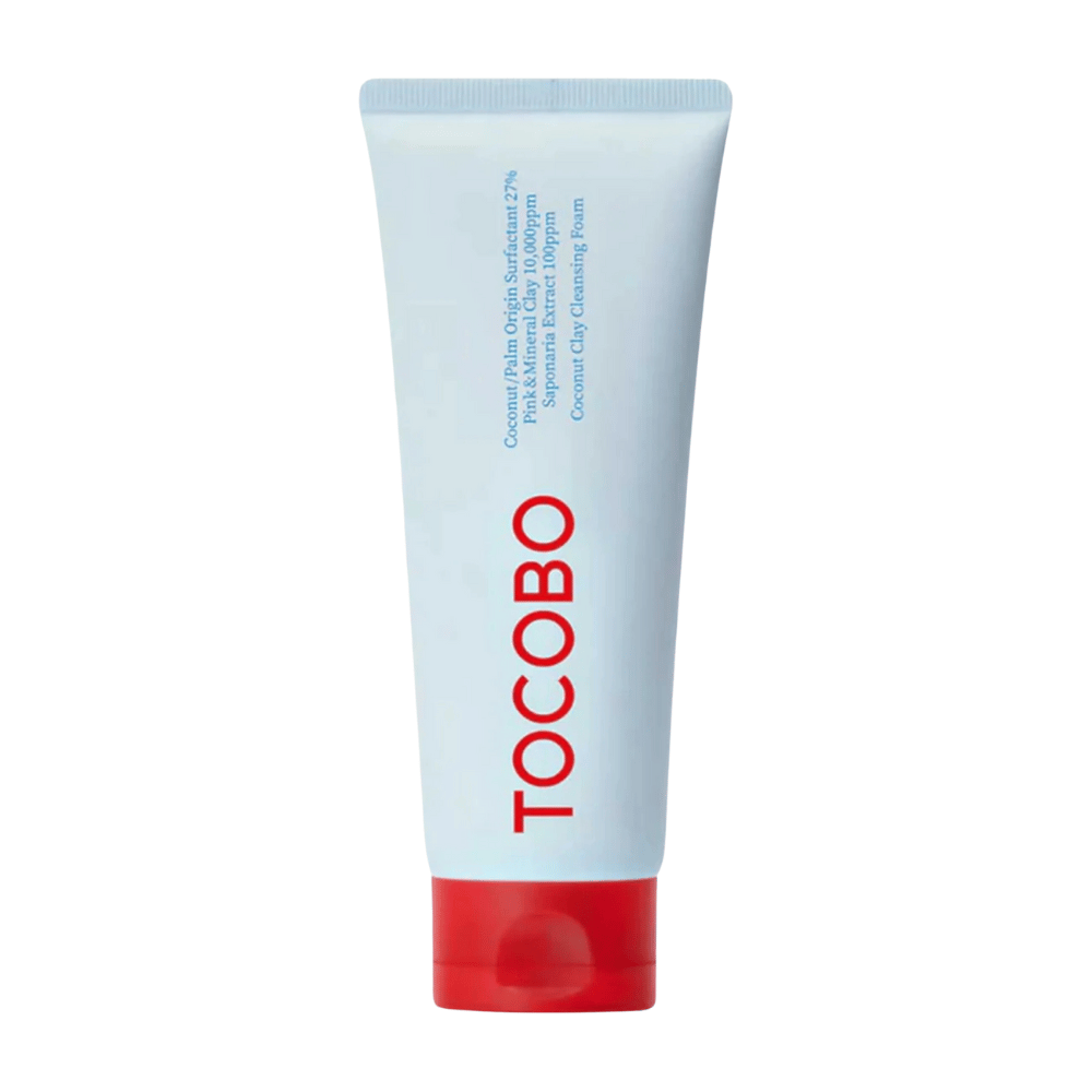 El tubo de TOCOBO Coconut Clay Cleansing Foam es visible. El tubo es de color azul claro con una tapa roja y el texto "TOCOBO" en letras grandes en la parte delantera. El producto se describe como una espuma limpiadora de arcilla de coco y contiene ingredientes naturales.