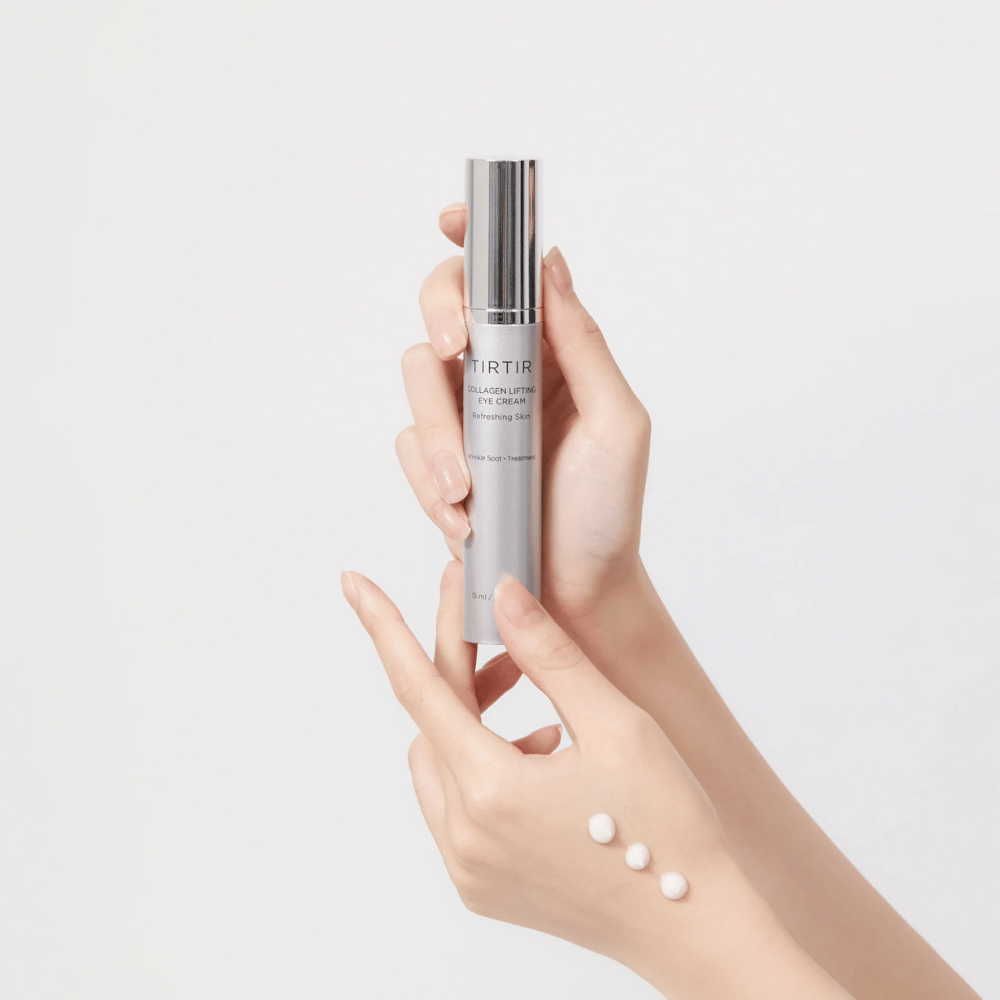 Manos sosteniendo un tubo con TIRTIR Collagen Lifting Eye Cream, con producto exprimido en el dorso de la mano.