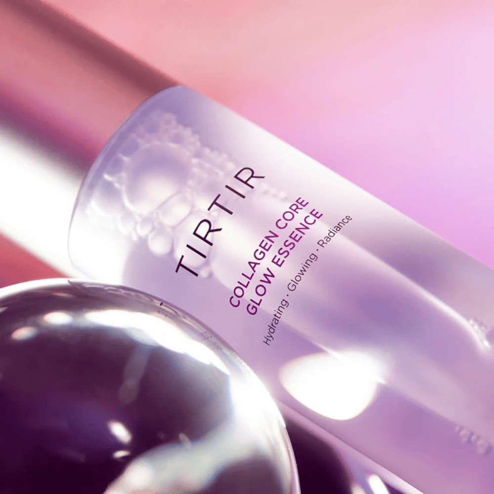 Primer plano de TIRTIR Collagen Core Glow Essence – esencia que aporta luminosidad en una botella lila elegante con enfoque en la hidratación y el brillo natural de la piel.
