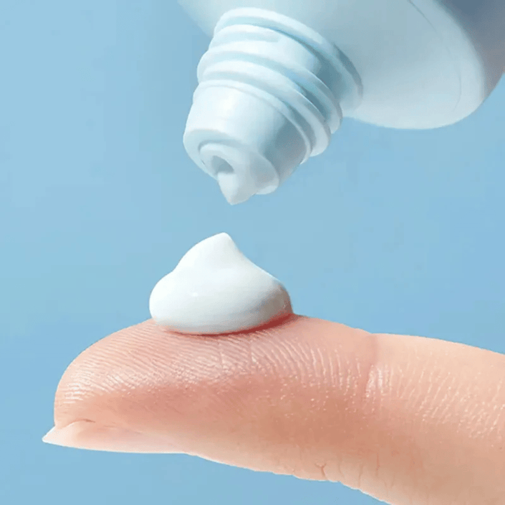 Primer plano de Torriden DIVE-IN Moisture Sun Cream con una textura suave e hidratante dispensada en la yema del dedo para la protección solar diaria.