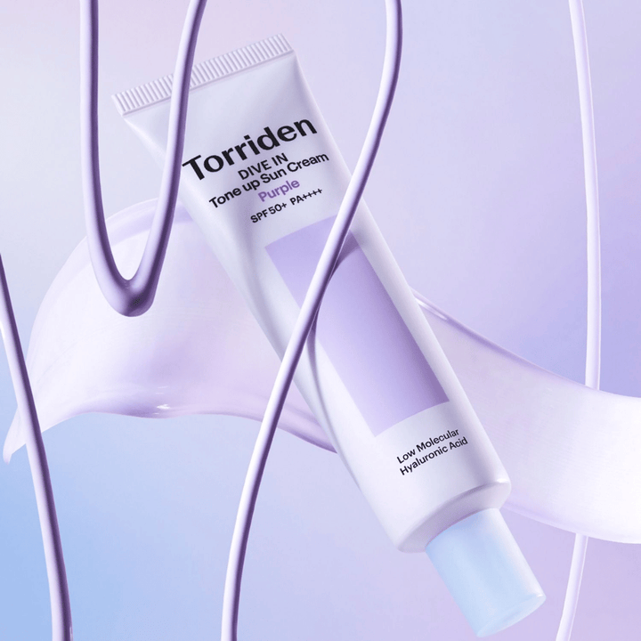 Torriden DIVE IN Tone Up Sun Cream Purple SPF50+ PA++++ presentada en un entorno creativo de producto con detalles lilas que resaltan la fórmula hidratante.