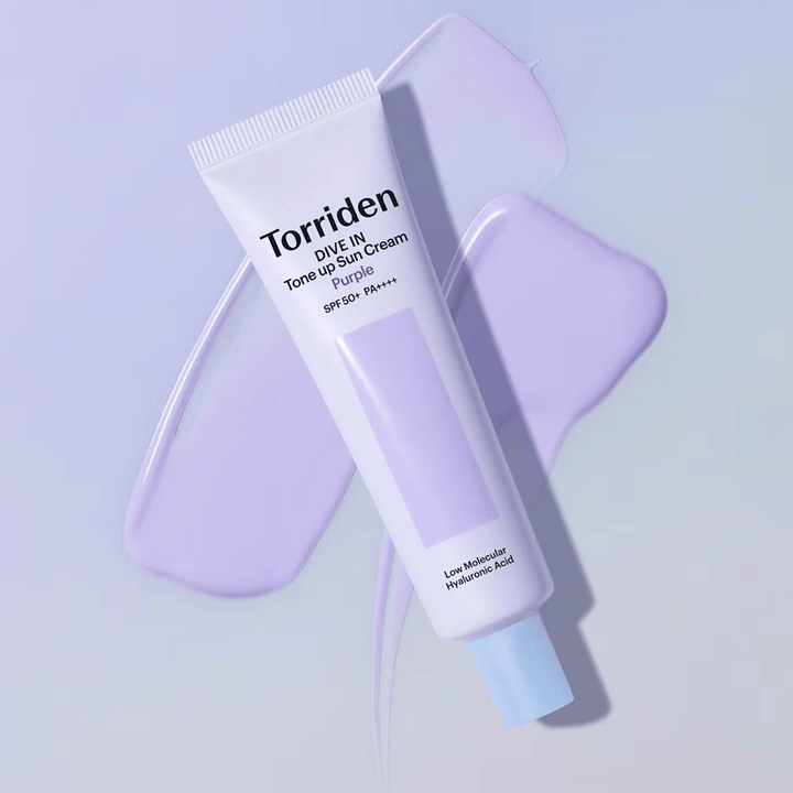 Torriden DIVE IN Tone Up Sun Cream Purple colocada sobre crema lila extendida que destaca el efecto unificador del tono y aportador de luminosidad.
