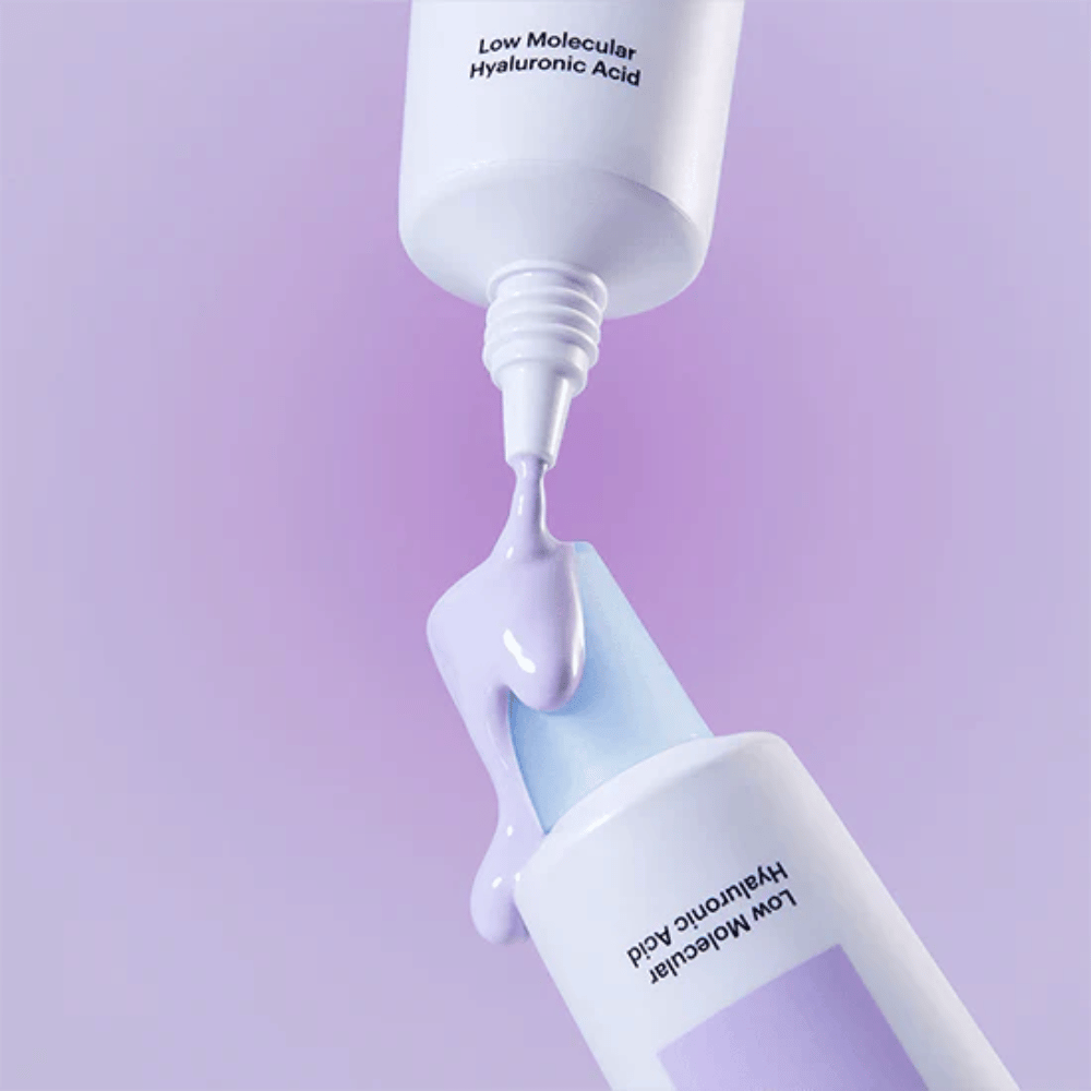 Primer plano de Torriden DIVE IN Tone Up Sun Cream Purple donde la crema lila se aplica desde el tubo para ilustrar la consistencia del producto.