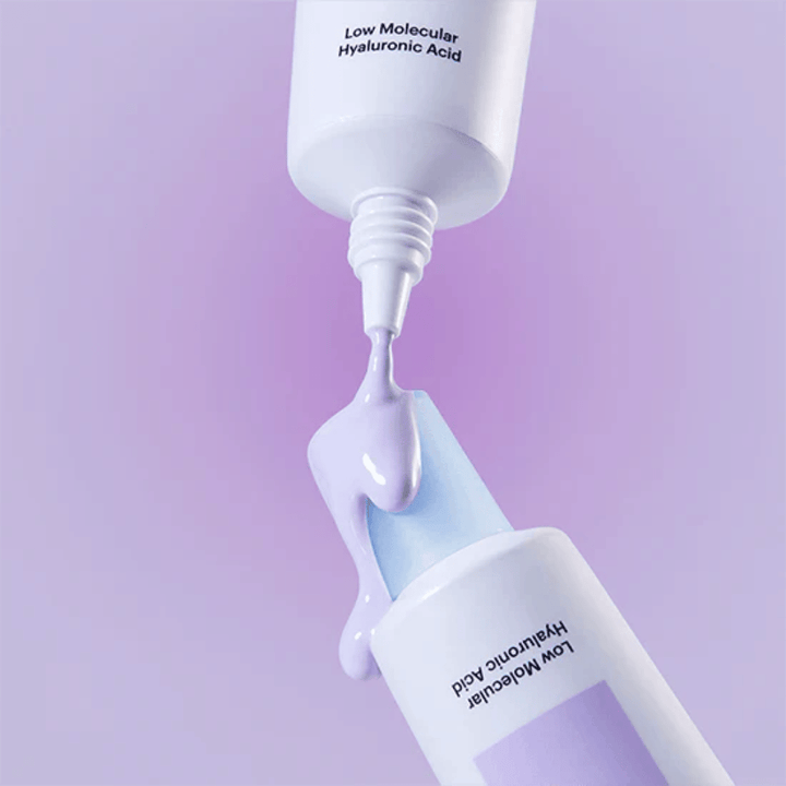 Primer plano de Torriden DIVE IN Tone Up Sun Cream Purple donde la crema lila se aplica desde el tubo para ilustrar la consistencia del producto.