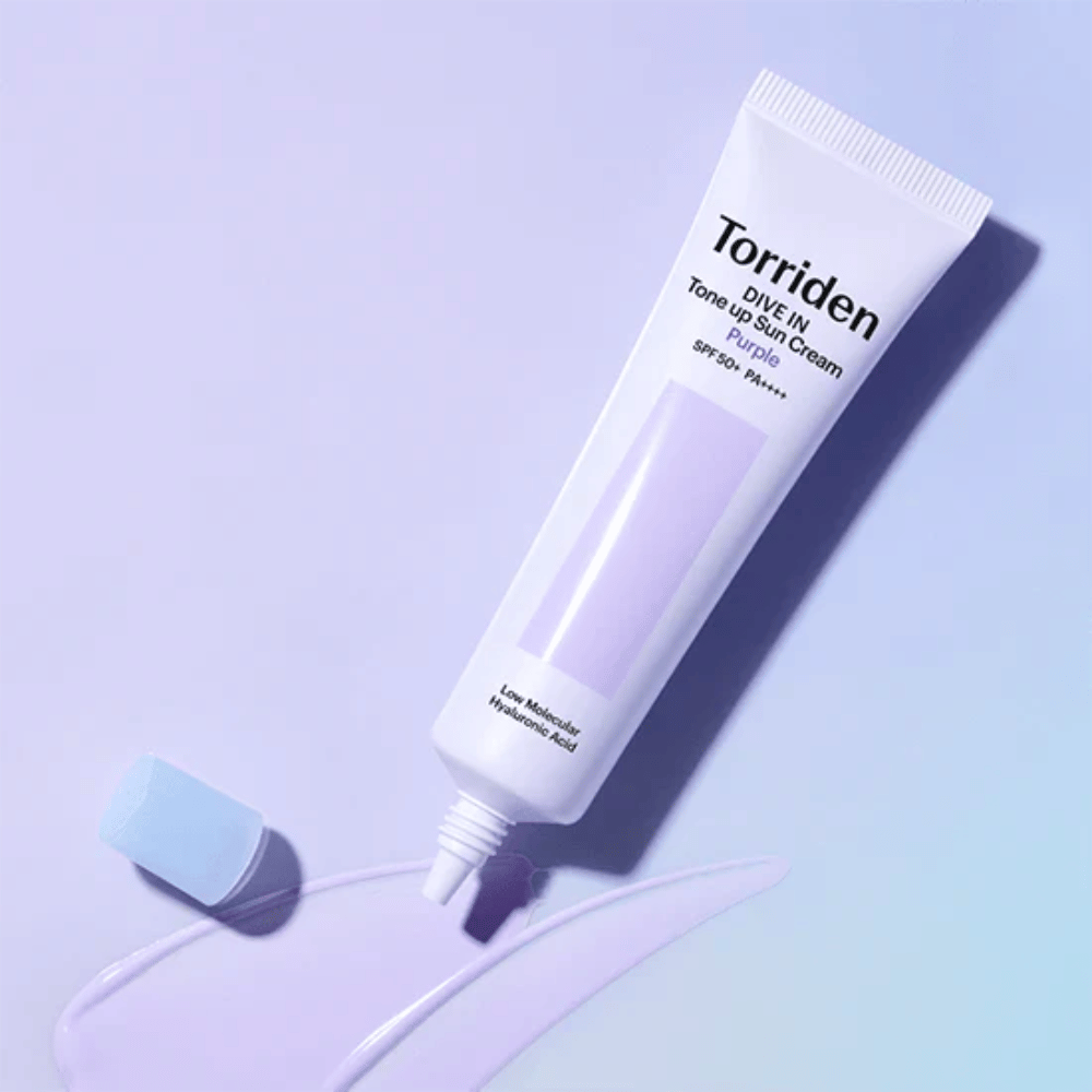 Tubo abierto de Torriden DIVE IN Tone Up Sun Cream Purple con textura de protector solar con tono lila que muestra la fórmula correctora del color del producto.