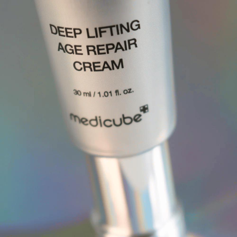 Primer plano de Medicube Deep Lifting Age Repair Cream en envase plateado, 30 ml.