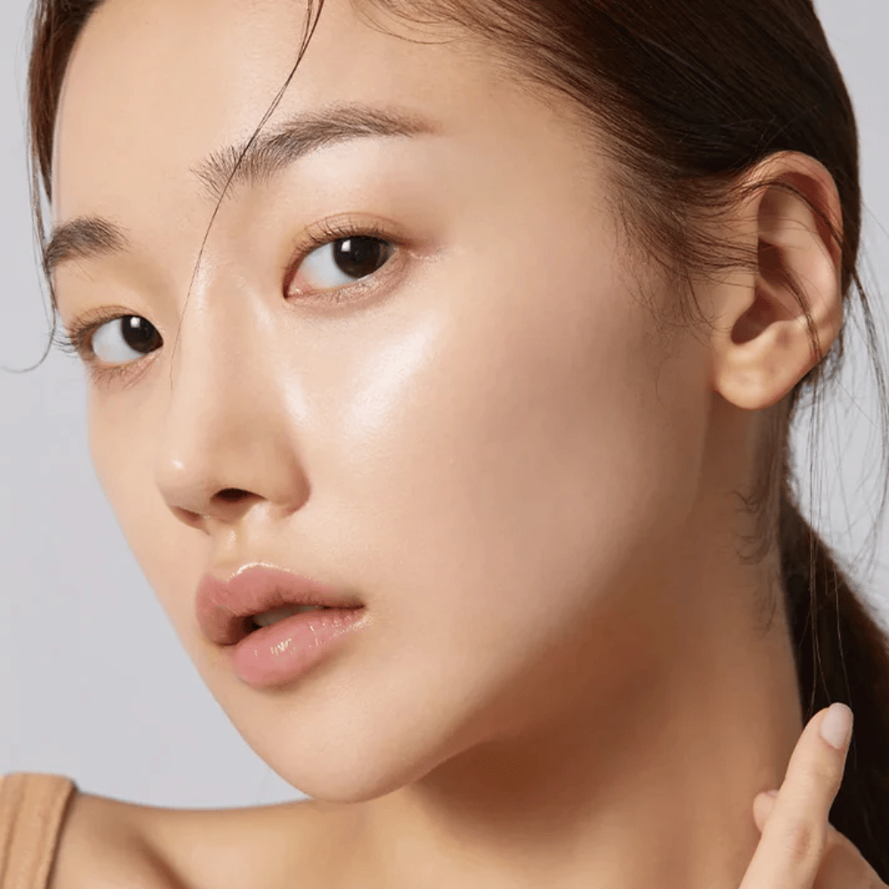 Primer plano de modelo con piel clara, hidratada y brillo natural después de usar Sheet mask coreano.