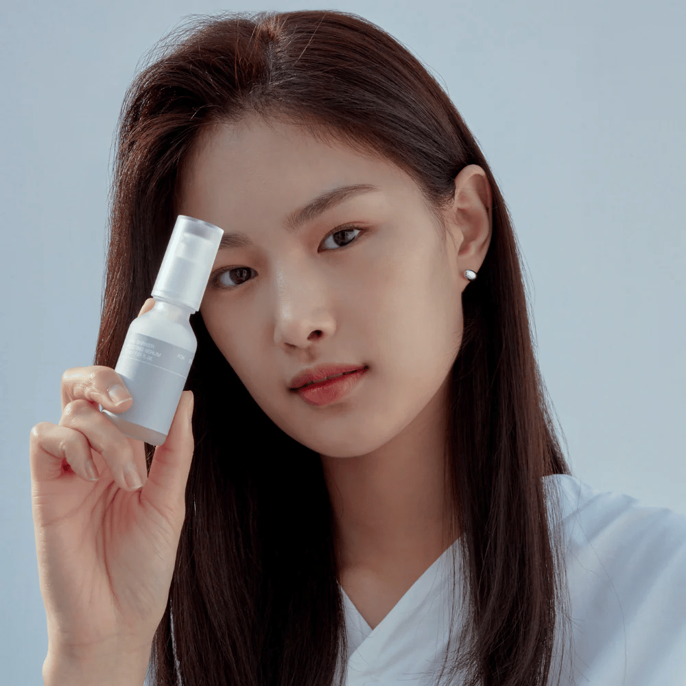 Modelo sostiene Celimax Dual Barrier Boosting Serum, cuidado de la piel coreano que fortalece la barrera cutánea y calma la piel sensible.