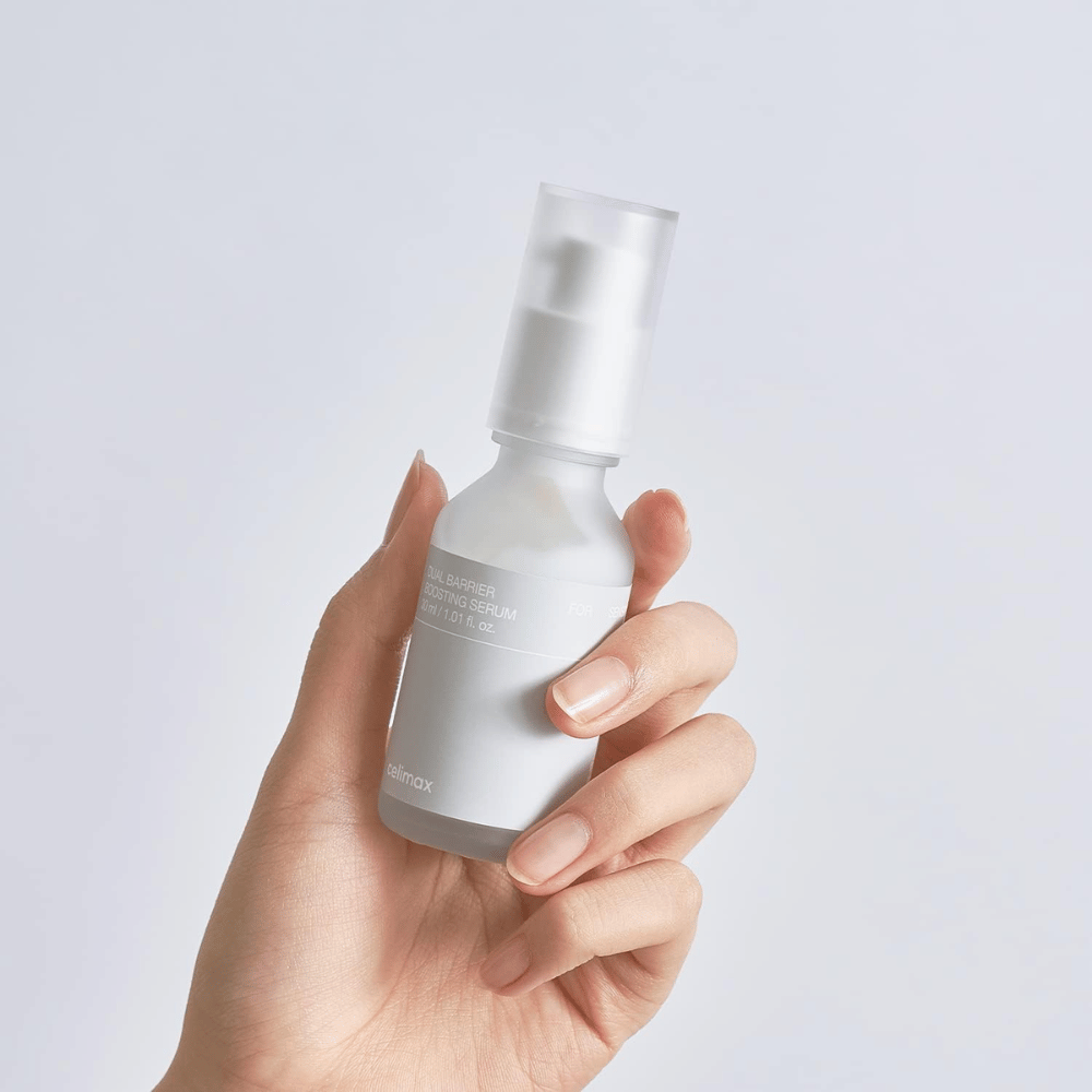 Celimax Dual Barrier Boosting Serum en mano, empaque minimalista que muestra suero coreano fortalecedor de barrera para piel sensible.