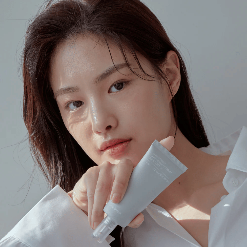 Modelo sosteniendo Celimax Dual Barrier Skin Wearable Cream, crema facial calmante y fortalecedora de la barrera para piel sensible y seca.