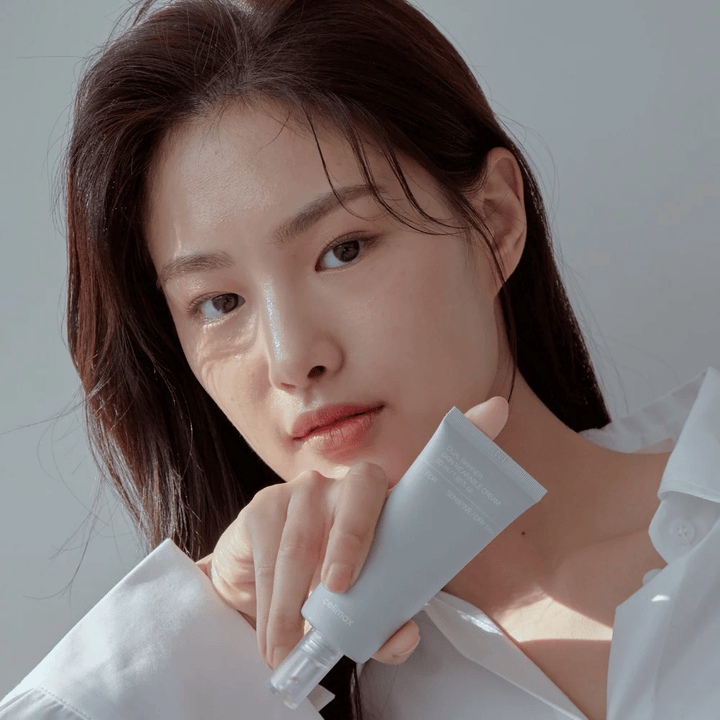 Modelo sosteniendo Celimax Dual Barrier Skin Wearable Cream, crema facial calmante y fortalecedora de la barrera para piel sensible y seca.