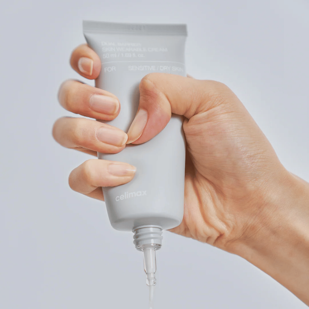 Mano aplicando Celimax Dual Barrier Skin Wearable Cream, crema facial fortalecedora de la barrera para piel sensible y seca que proporciona hidratación duradera y protege la barrera cutánea.