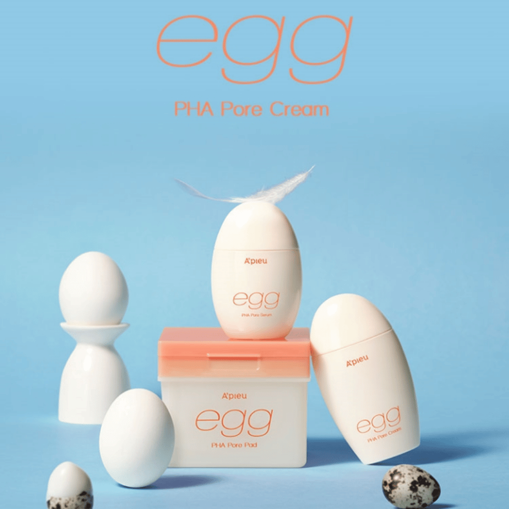 A'pieu Egg PHA Pore-serie – productos en forma de huevo como suero, crema y almohadillas, elegantemente dispuestos sobre un fondo azul con huevos y plumas que simbolizan el cuidado suave de la piel.