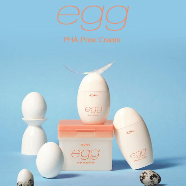 A'pieu Egg PHA Pore-serie – äggformade produkter som serum, kräm och pads, stilrent arrangerade på blå bakgrund med ägg och fjäder som symboliserar skonsam hudvård.