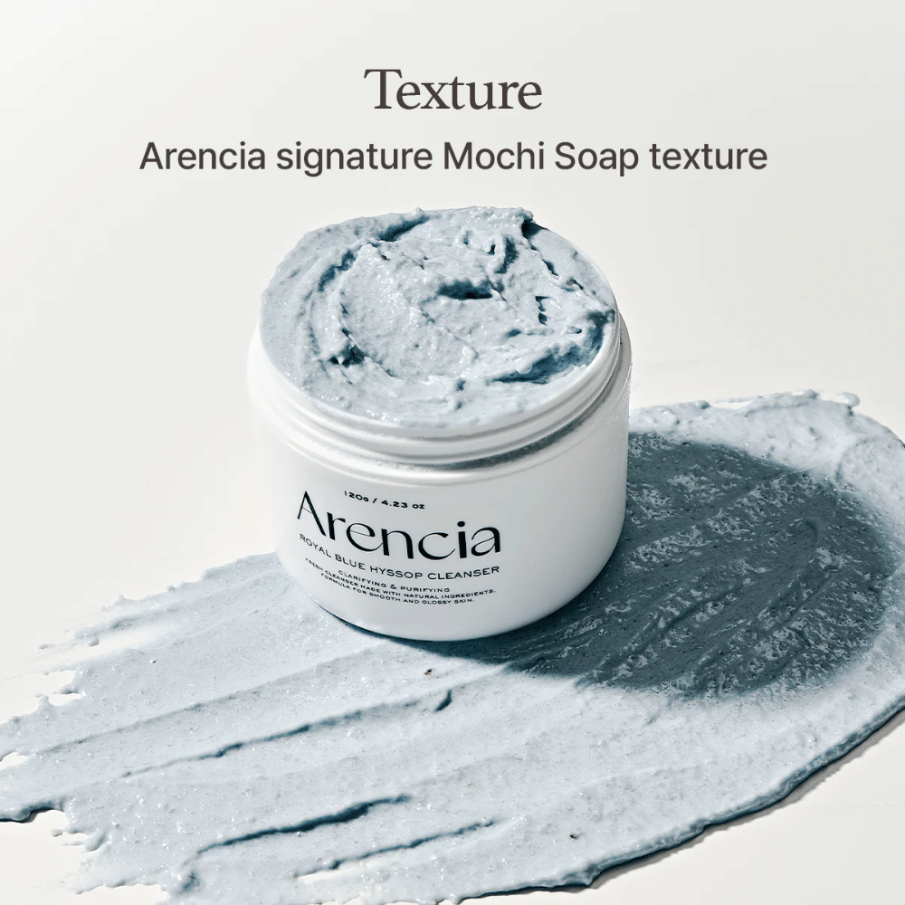 Frasco abierto con Arencia Fresh Blue Hyssop Rice Mochi Cleanser, colocado sobre una capa extendida de la fórmula limpiadora azul y cremosa que muestra su textura similar a mochi.