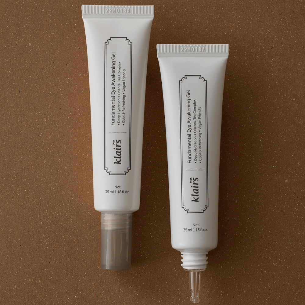 Imagen de producto que muestra Klairs Fundamental Eye Awakening Gel en dos versiones: un tubo cerrado y un tubo abierto que resalta la punta estrecha del aplicador. El envase tiene un diseño blanco minimalista y destaca el enfoque del producto en la hidratación, la sensación refrescante y el cuidado revitalizante del área de los ojos.