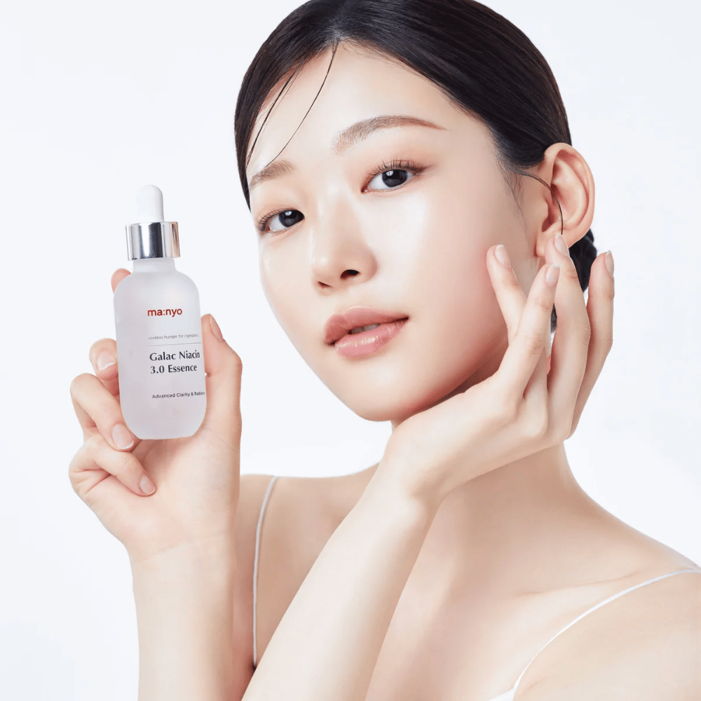 Mujer con piel radiante sostiene Ma:nyo Galac Niacin 3.0 Essence - esencia coreana que proporciona un tono de piel más uniforme y un brillo natural.