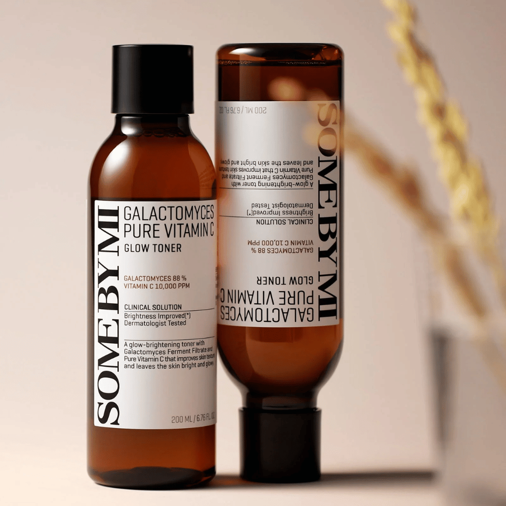 Imagen de SOME BY MI Galactomyces Pure Vitamin C Glow Toner. Las botellas tienen un diseño elegante con tonos marrones y tapa negra. El producto contiene 88% de galactomyces y 10,000 ppm de vitamina C, lo que promete mejorar el resplandor de la piel y proporcionar un tono de piel más fresco.