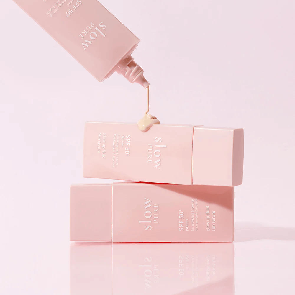 Slow Pure Glow Up Fluid Sun Serum con crema presionada desde la botella, muestra consistencia ligera y nutritiva.