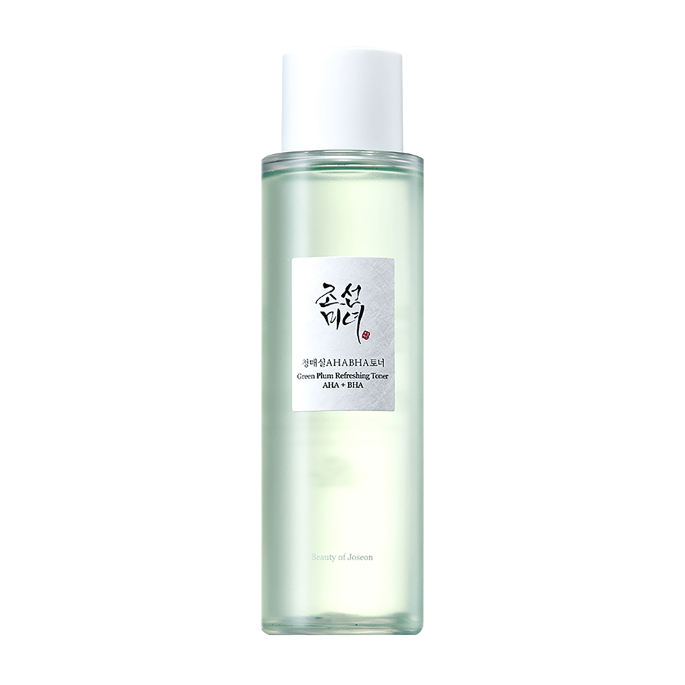 La botella de "Green Plum Refreshing Toner" AHA + BHA tiene un diseño elegante con un tapón blanco y un cuerpo transparente que muestra el líquido verde en su interior. La etiqueta tiene un texto negro y rojo elegante, lo que le da una sensación fresca y moderna.