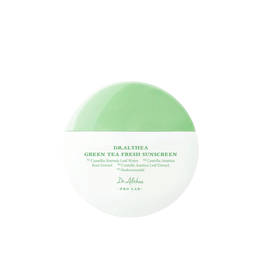 Crema solar redonda de Dr. Althea con envase verde y blanco y texto que resalta ingredientes como té verde y centella asiática, una crema solar química suave con propiedades calmantes.