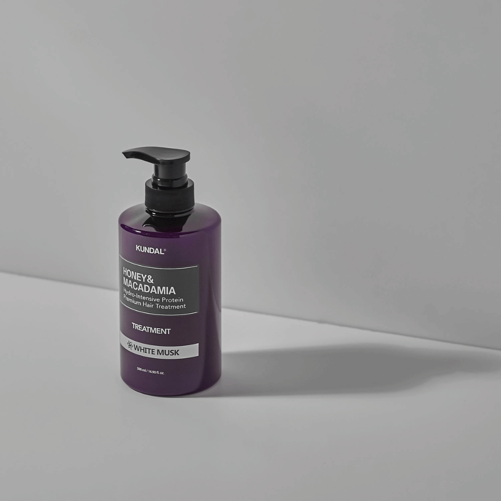 KUNDAL Honey & Macadamia Hydro-Intensive Protein Premium Hair Treatment White Musk en botella con bomba lila, 500 ml.