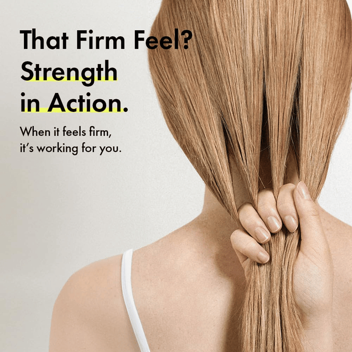 Persona sosteniendo su cabello para ilustrar hebras capilares más fuertes y una sensación de cabello más firme después de usar Grabity g0.0 Hair Lifting Shampoo Strong.